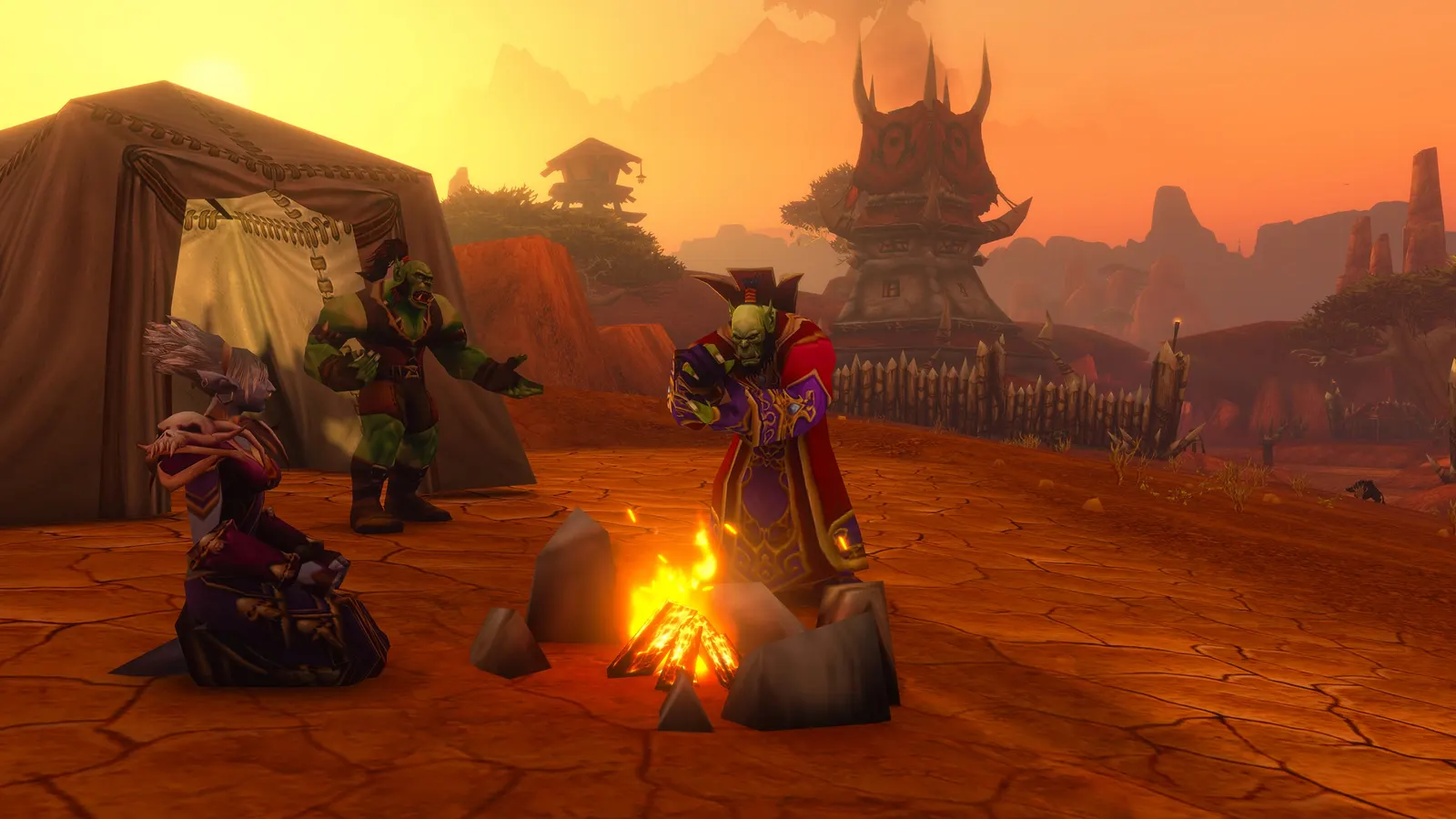 Characters sitting around a campfire at dusk