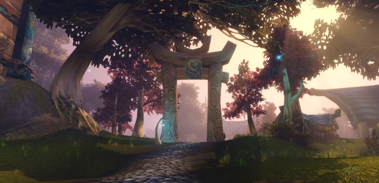 A stone archway on a path under twisted trees at dusk