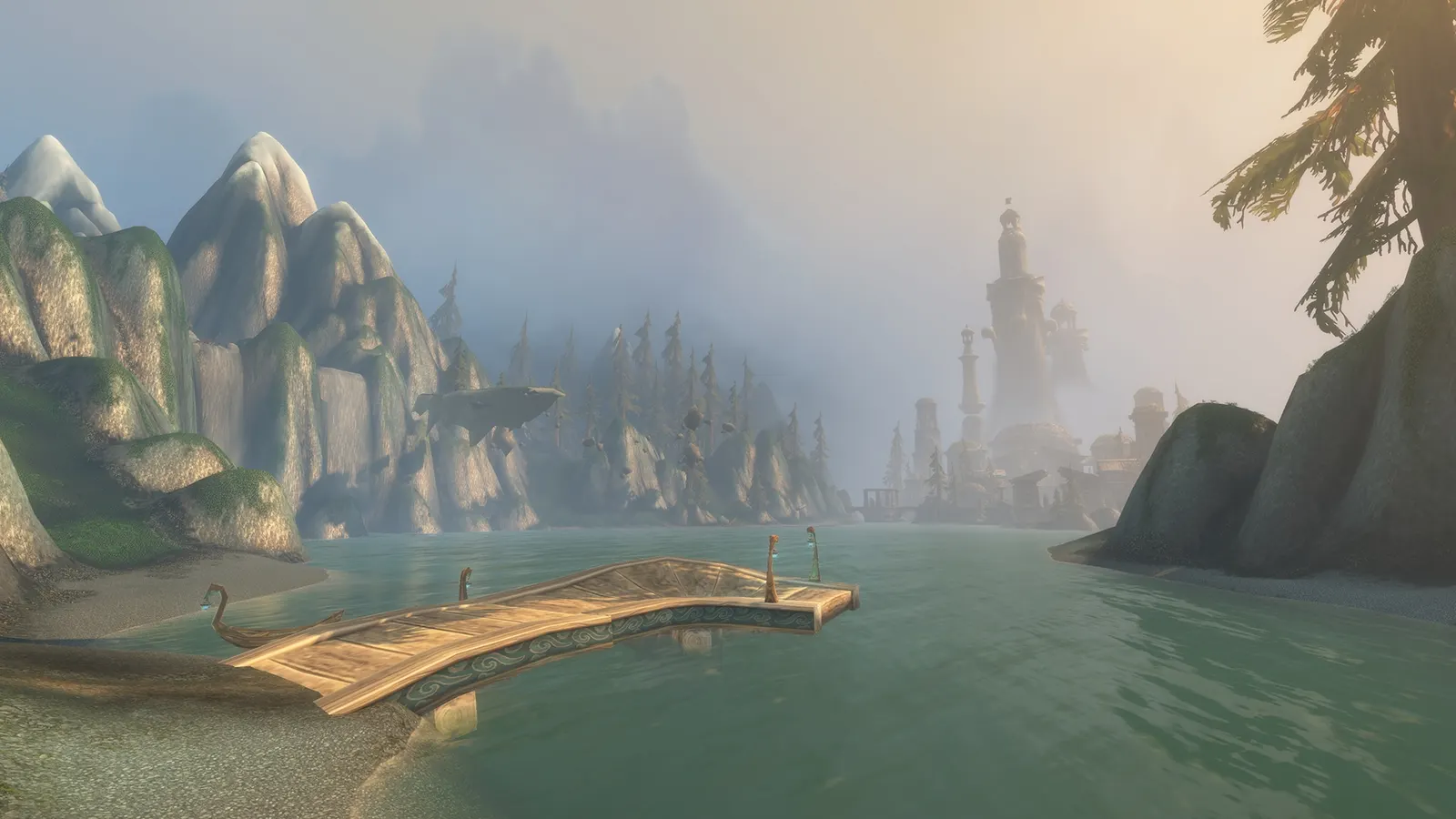 A lake with a wooden dock and distant spires among mountains