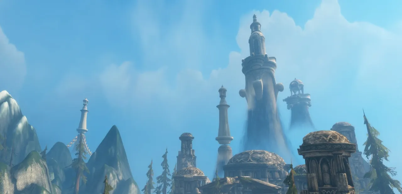 White spires rising above mountains in a pale blue sky