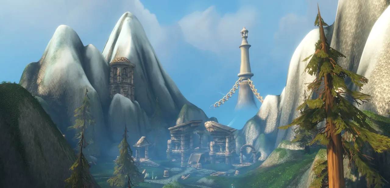 A white tower and buildings nestled between snowy mountains